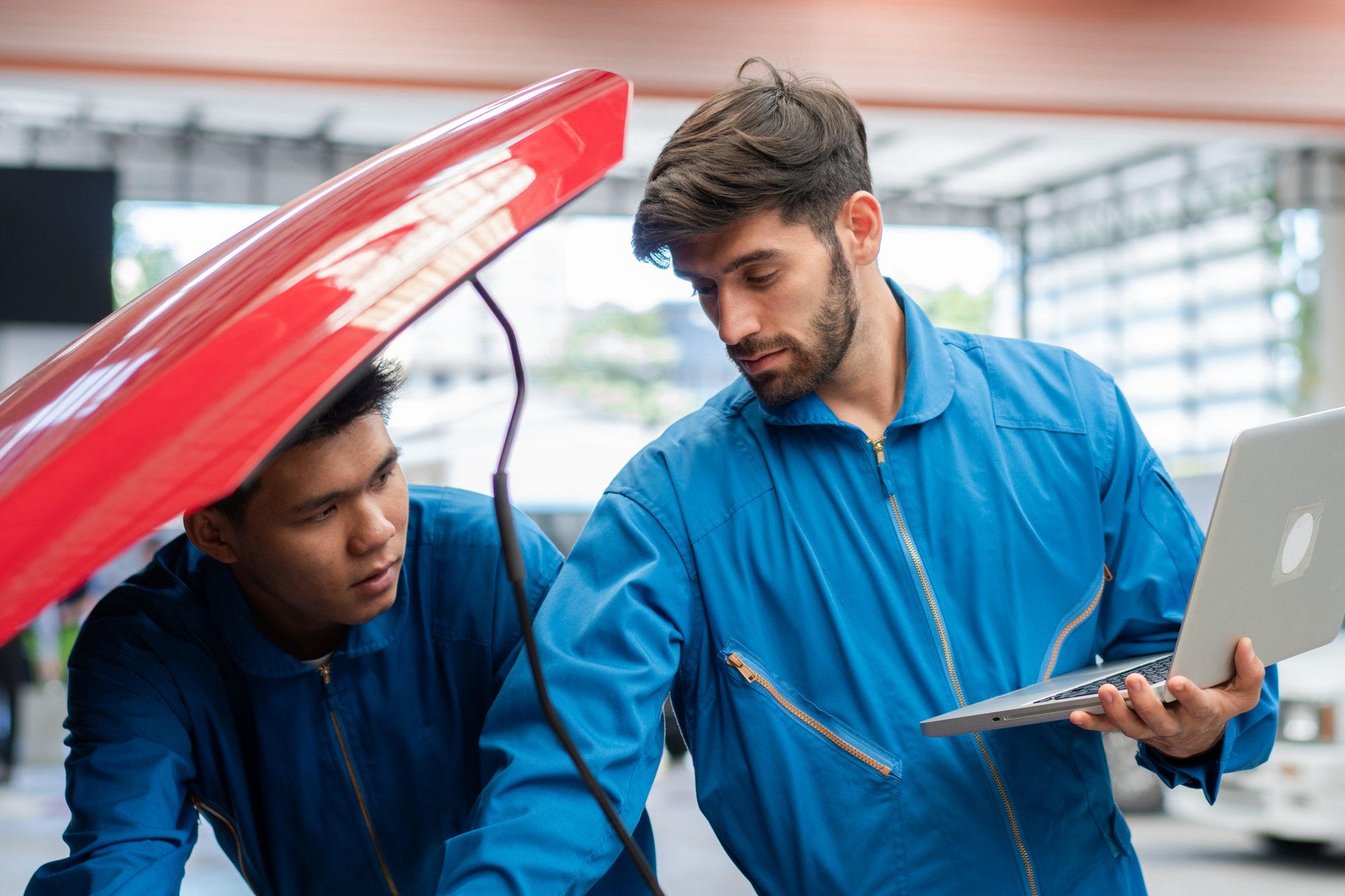 Technicians using diagnostic equipment to check a vehicle frame